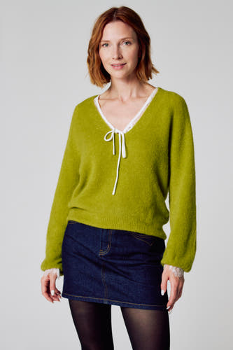 T-shirt V encol vert de Clouds of Fashion, terminé avec un col blanc et un détail de cordon, porté avec une jupe en denim et des sous-vêtements noirs.