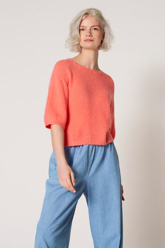 T-shirt rose avec col rond de Clouds of Fashion, porté avec un short bleu clair.
