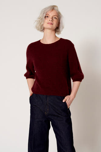 Veste de Bordeaux avec col rond de Clouds of Fashion, associée à un pantalon en denim foncé à larges jambes.