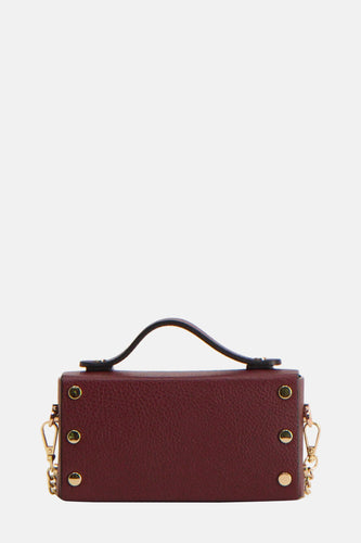 Bordeauxrode, rechthoekige handtas met zwarte handgreep en gouden details.