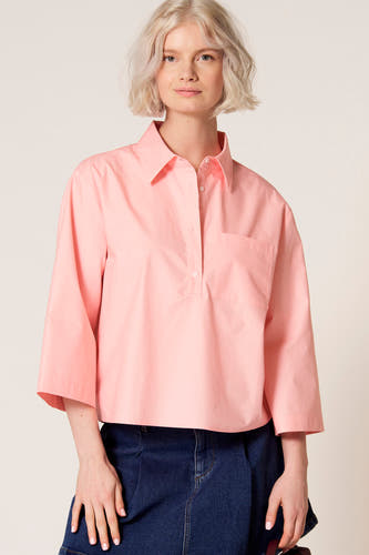 Chemisier rose à manches trois-quarts de Clouds of Fashion, avec une poche poitrine et porté avec une jupe bleu foncé.