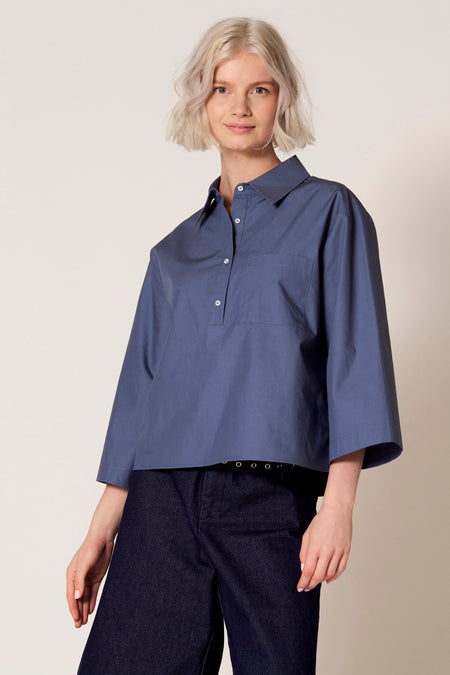 Chemisier bleu à manches trois-quarts de Clouds of Fashion, avec poche poitrine et porté avec un jean foncé.