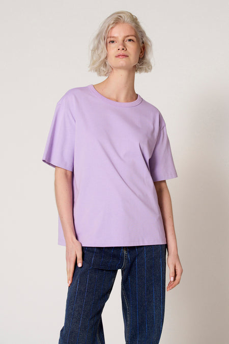 Paars T-shirt met korte mouwen van Clouds of Fashion, gedragen met donkerblauwe jeans met verticale strepen.