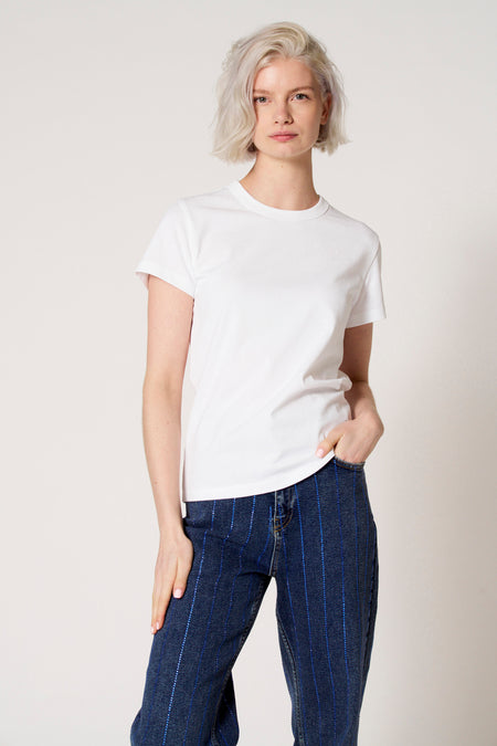Wit T-shirt met korte mouwen van Clouds of Fashion, gedragen met blauwe jeans met verticale strepen.