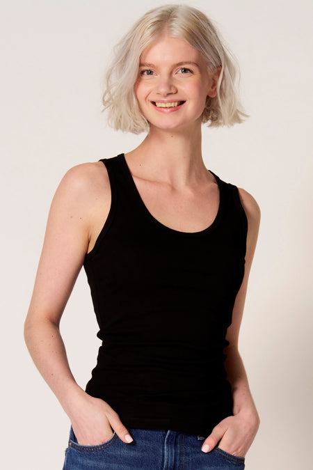 Zwarte singlet van Clouds of Fashion, met een ronde hals en een getailleerde pasvorm, gedragen met een jeans.
