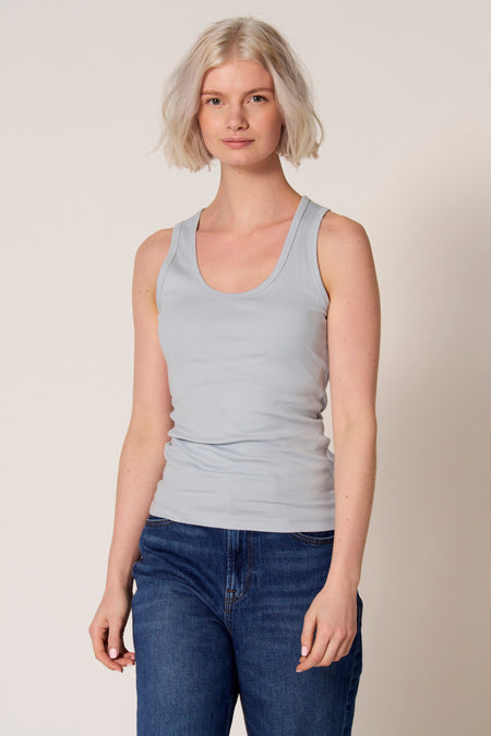 Blauwe singlet van Clouds of Fashion, gedragen met een donkere spijkerbroek.