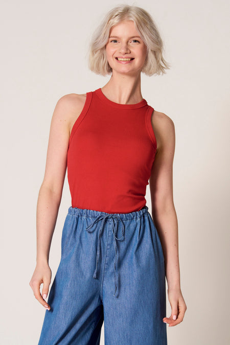 Rode singlet van Clouds of Fashion, gedragen met denim broek met trekkoord en wijde pijpen.