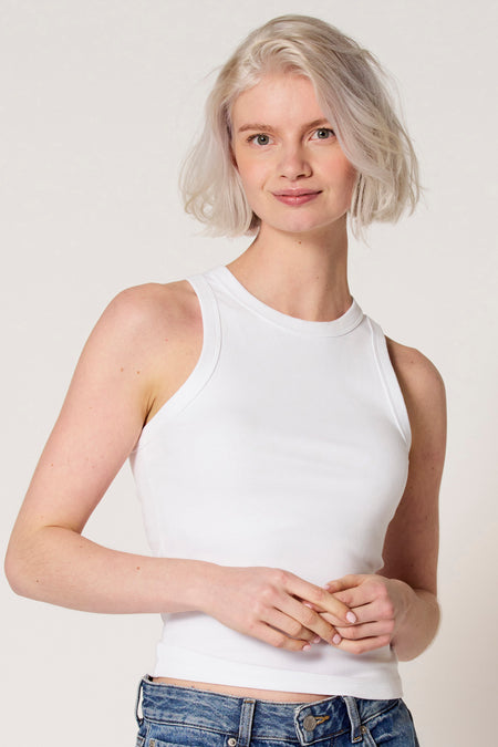 Witte singlet van Clouds of Fashion, gedragen met een spijkerbroek, tegen een lichte achtergrond.
