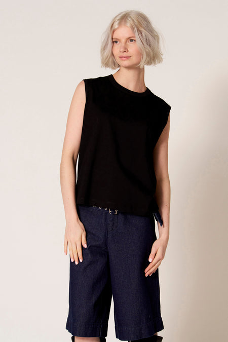 Zwarte singlet van Clouds of Fashion, gedragen met denim culottes en een riem met ringdetail.
