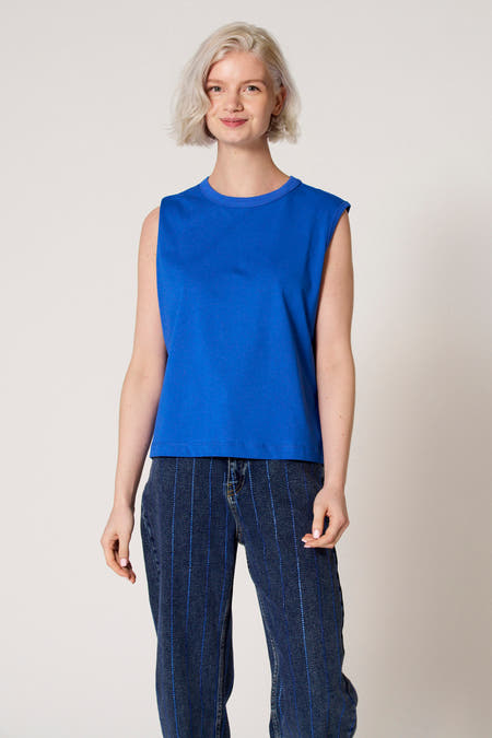 Débardeur bleu de Clouds of Fashion, porté avec un pantalon en jean rayé.
