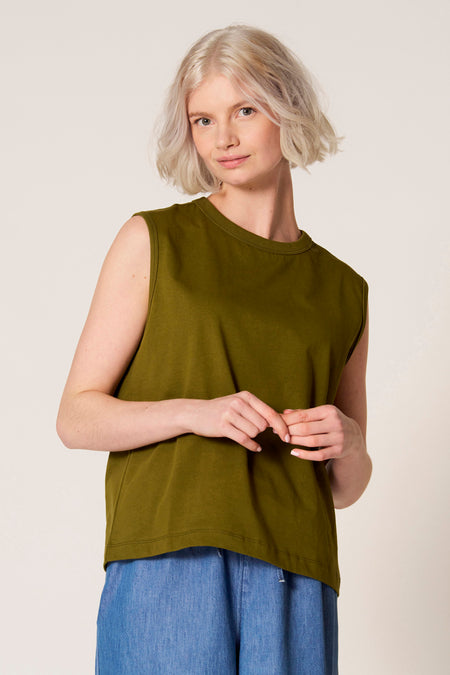 Groene singlet van Clouds of Fashion, gecombineerd met een blauwe broek.