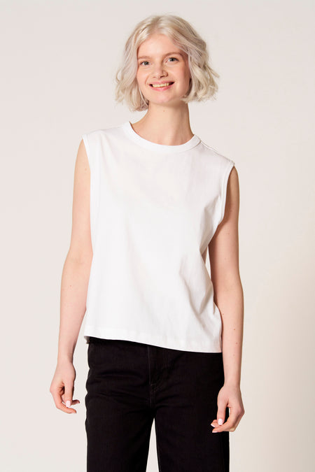 Witte singlet van Clouds of Fashion, gedragen met zwarte jeans.