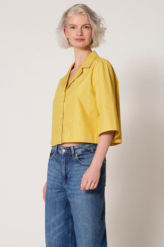 Blouse de Clouds ou Fashion, avec des manches trois-quarts, portée avec un jean bleu.