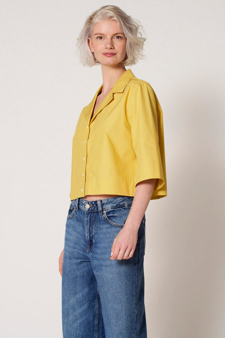 Gele blouse van Clouds of Fashion, met driekwart mouwen, gedragen met een blauwe jeansbroek.