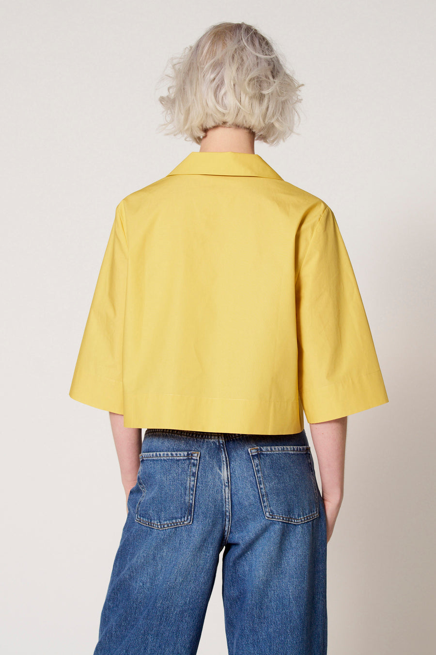 Blouse jaune à manches trois-quarts de Clouds of Fashion, vue de derrière, associée à un jean bleu.