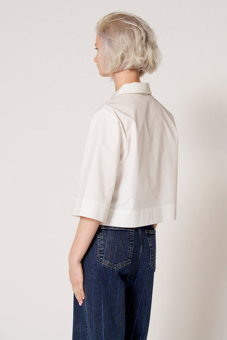 Witte blouse met driekwart mouwen van Clouds of Fashion, met een kraag en gecombineerd met een jeans met blauwe strepen.