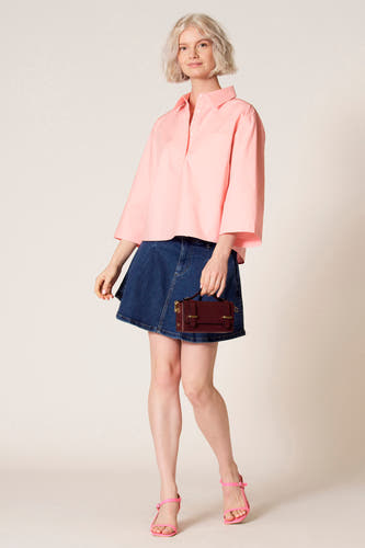 Blouse rose à manches trois-quarts de Clouds of Fashion, avec poche poitrine, associée à une jupe en denim.