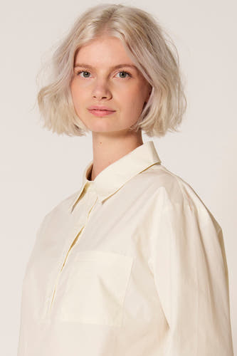 Chemisier blanc de Clouds of Fashion, à manches longues et poche poitrine, porté par un mannequin.