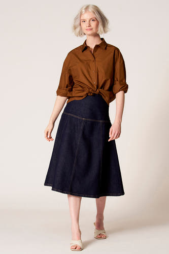 Blouse brune à longues manches de Clouds of Fashion, avec un col classique et des manches longues portées avec une jupe bleu marine.