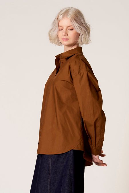 Blouse brune à longues manches de Clouds of Fashion, avec un col classique et portée avec une jupe sombre.