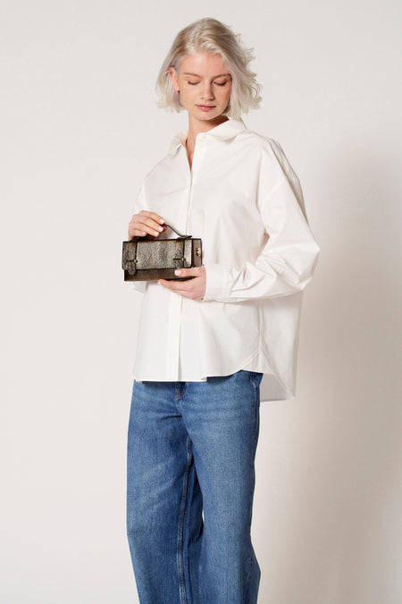 Blouse blanche à longues manches de Clouds of Fashion, portée avec des jeans.