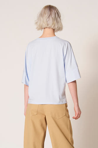 Blauw T-shirt met korte mouwen van Clouds of Fashion, met wijde mouwen en gecombineerd met een bruine broek.

