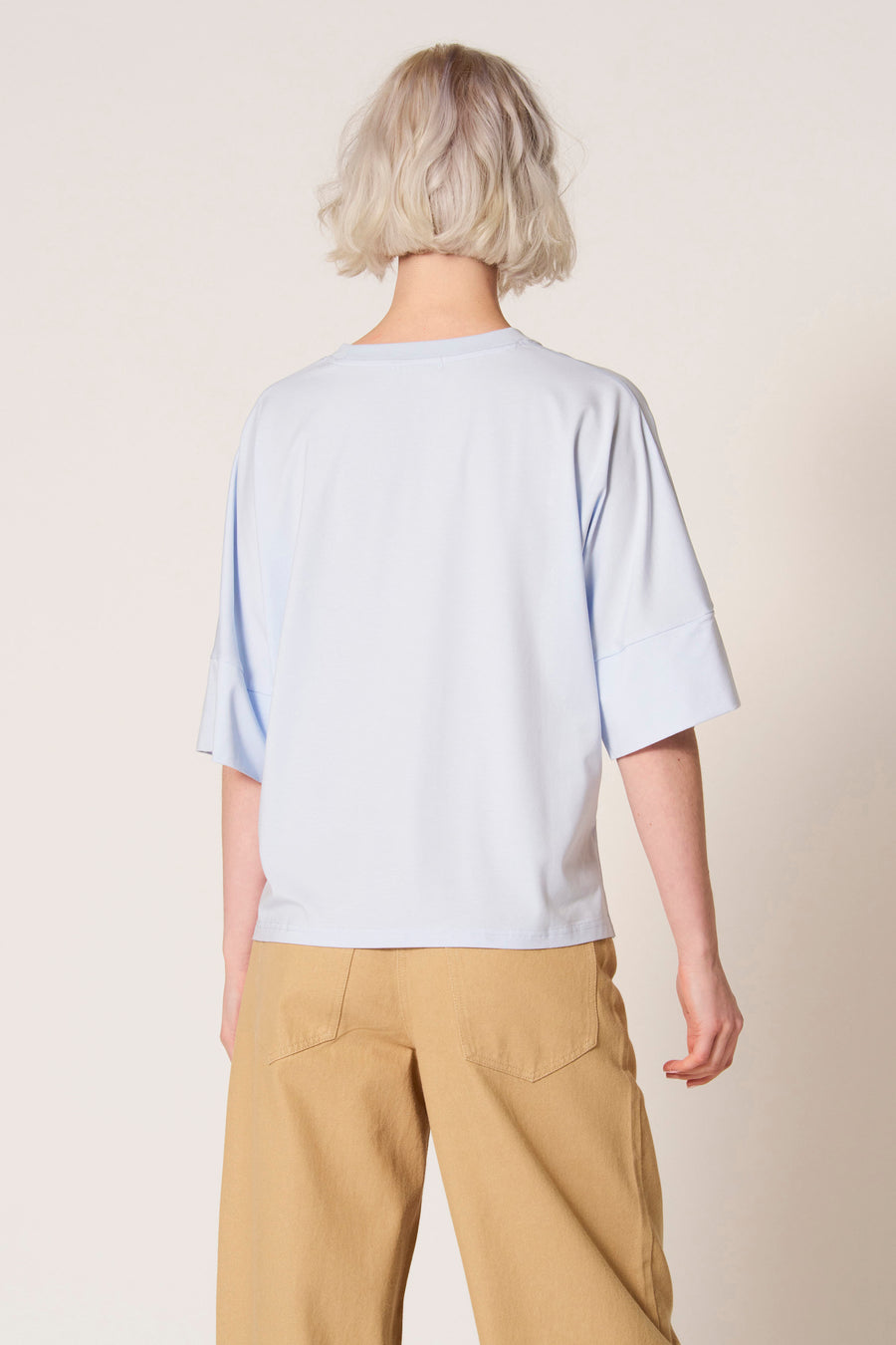 Blauw T-shirt met korte mouwen van Clouds of Fashion, met wijde mouwen en gecombineerd met een bruine broek.
