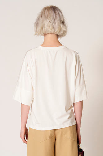 T-shirt écru à manches courtes de Clouds of Fashion, vu de dos, combiné avec un pantalon kaki.