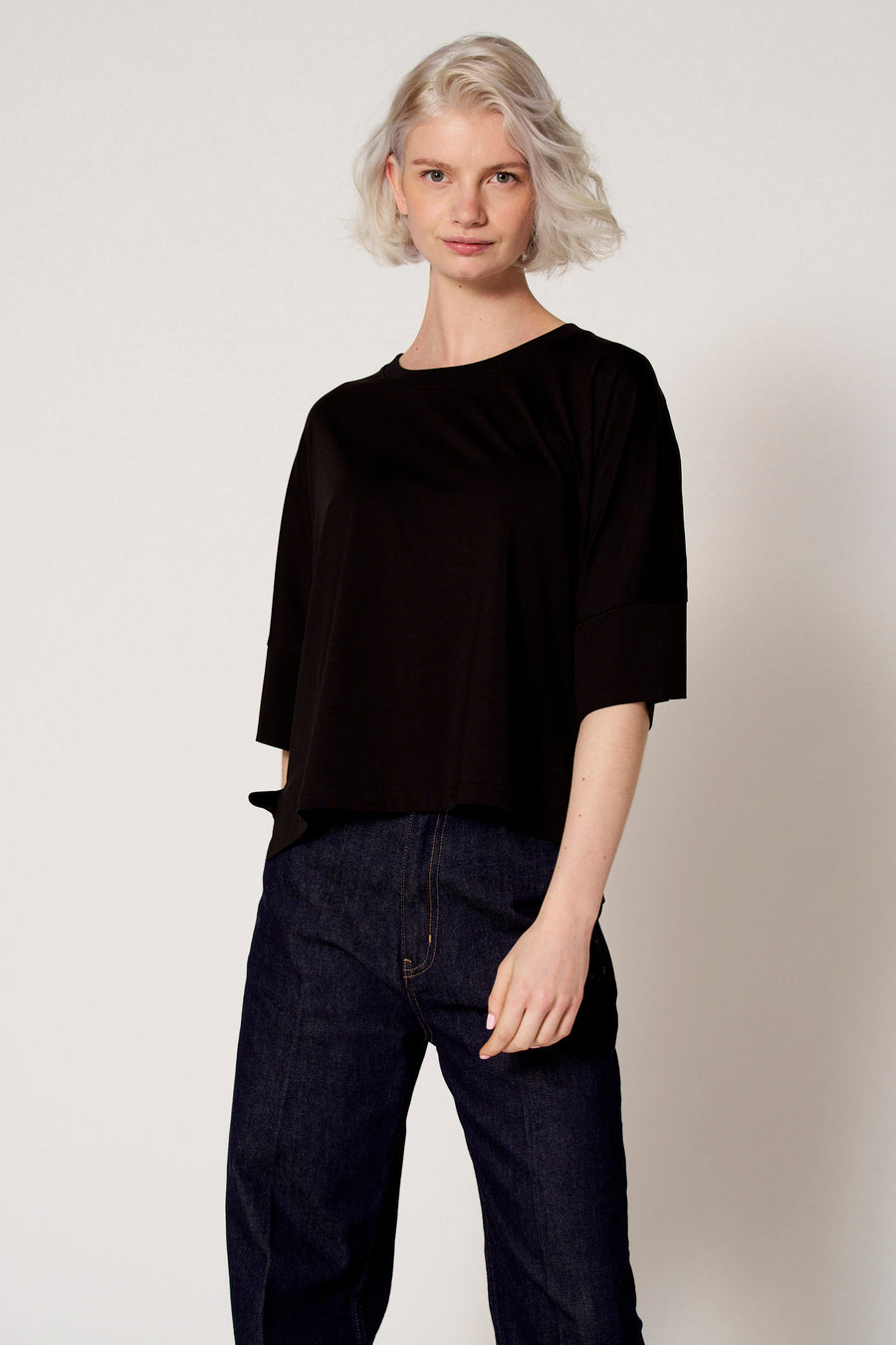 T-shirt noir à manches courtes de Clouds of Fashion, coupe droite et pantalon en jean foncé.