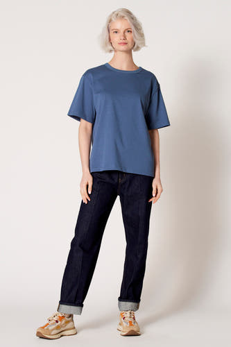T-shirt bleu à manches courtes de Clouds of Fashion, vu de dos, avec un jean foncé.