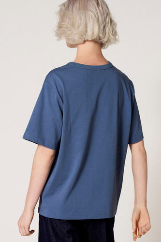 T-shirt bleu à manches courtes de Clouds of Fashion, vu de dos, combiné avec un pantalon foncé.