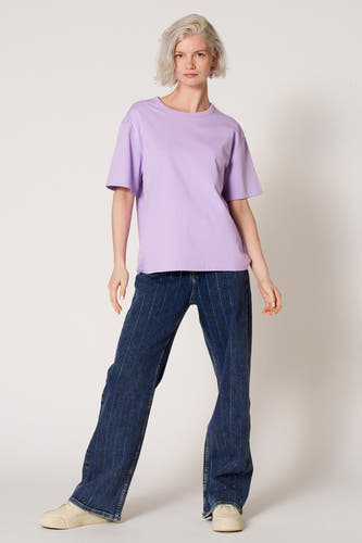 T-shirt à manches courtes violet de Clouds of Fashion, de couleur unie, associé à un jean à rayures verticales.