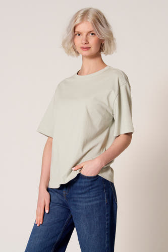 Blauw T-shirt met korte mouwen van Clouds of Fashion, gedragen met een donkerblauwe spijkerbroek, hand in de zak.