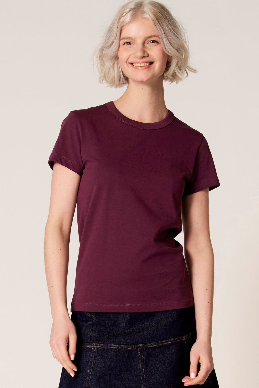 T-shirt à manches courtes violet de Clouds of Fashion, vu de dos, combiné avec une jupe bleu foncé.