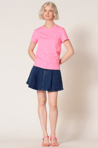 T-shirt rose à manches courtes de Clouds of Fashion, combiné avec une jupe en jean et des sandales roses.
