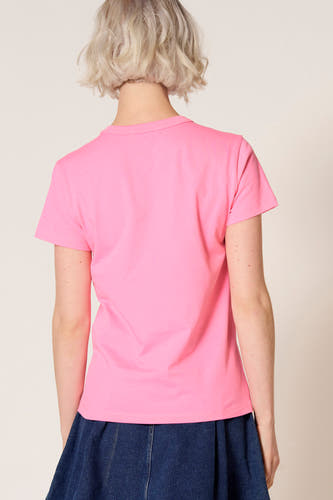 T-shirt à manches courtes rose de Clouds of Fashion, avec un col rond simple et porté avec une jupe bleu foncé.