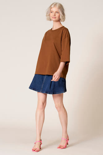T-shirt marron à manches courtes de Clouds of Fashion, vu de dos, combiné avec une jupe en jean.