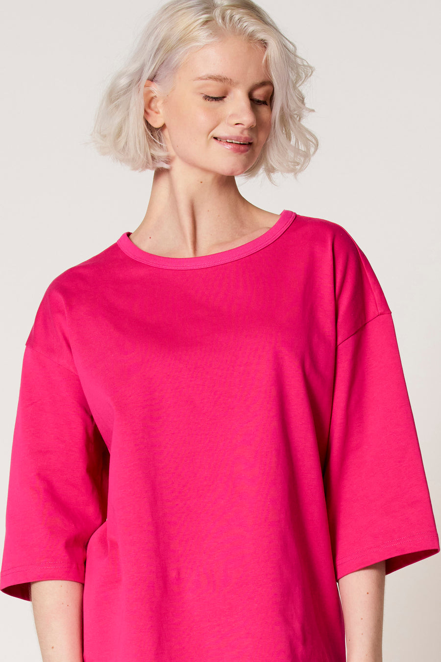 Roze T-shirt met korte mouwen van Clouds of Fashion, met een losse pasvorm en ronde halslijn, gedragen door een model.
