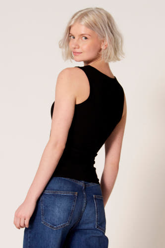 Débardeur noir de Clouds of Fashion, avec une coupe ajustée, porté avec un jean bleu.
