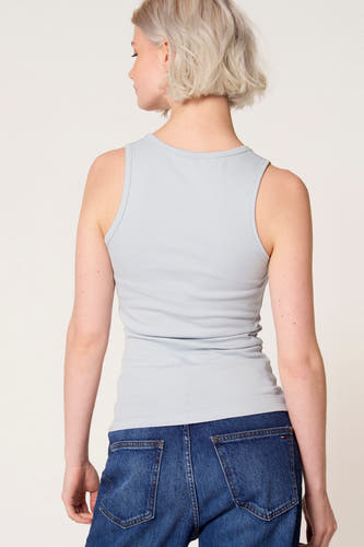 Débardeur bleu de Clouds of Fashion, avec un design uni, porté avec un jean bleu foncé.
