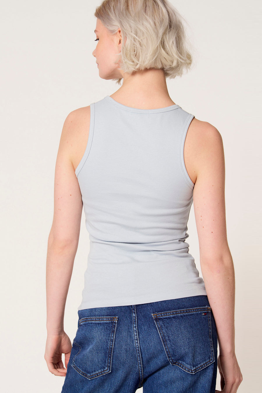 Débardeur bleu de Clouds of Fashion, avec un design uni, porté avec un jean bleu foncé.