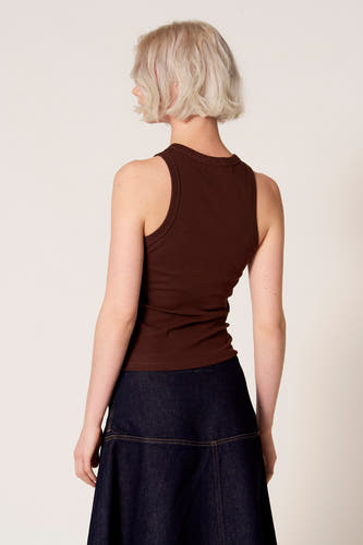 Bruine singlet van Clouds of Fashion, met een eenvoudige halslijn, gedragen met een donkerblauwe denim rok.