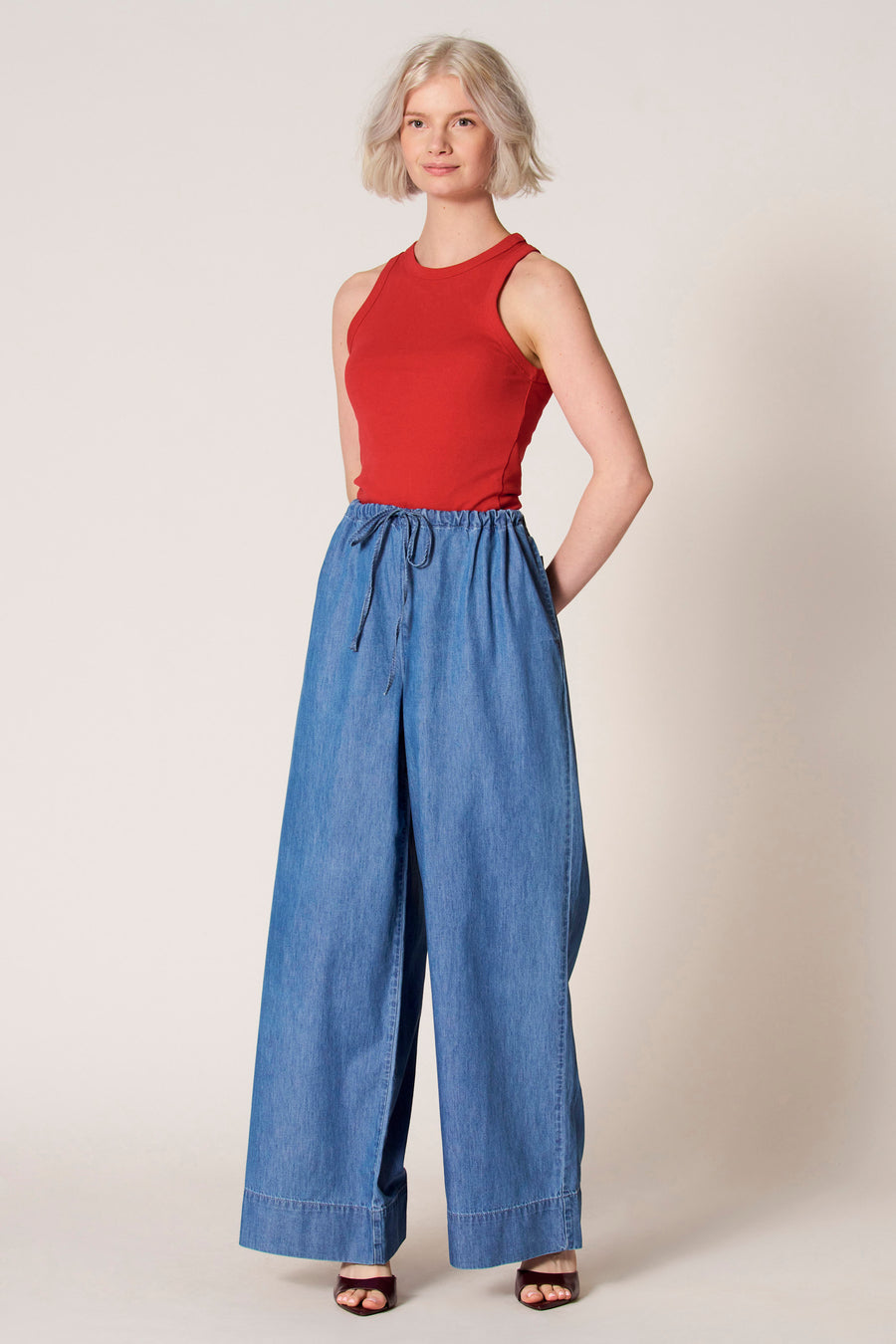 Débardeur rouge de Clouds of Fashion, avec un col rond, combiné avec un pantalon bleu à taille élastique.