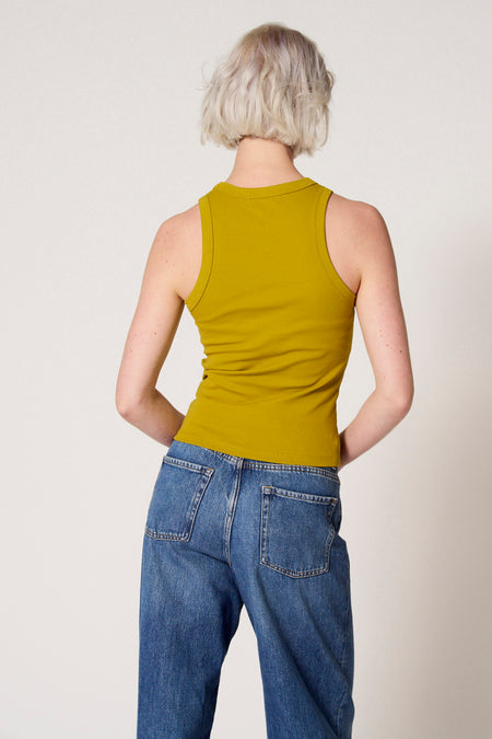 Groene singlet van Clouds of Fashion, gezien van achteren, gecombineerd met een blauwe jeans.