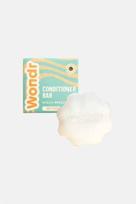 Barre de revitalisant blanche de Wondr Care, avec emballage sarcelle à motif de vagues orange et logo 'Wondr'.