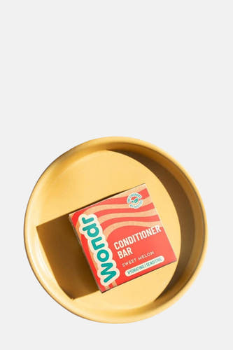 Conditionneur barre avec melon doux de WONDR CARE, posé sur un plateau jaune.