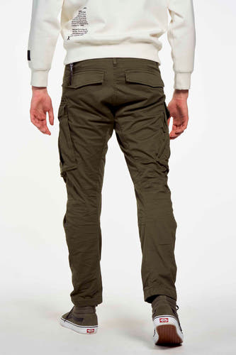 Pantalon cargo vert de G-Star RAW RAW avec des po et et portéésées sneakers gris et un pull blanc.