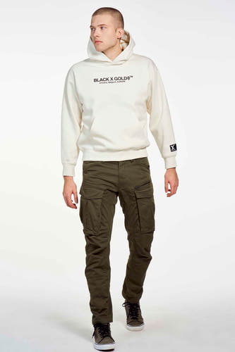 Groene cargobroek van G-Star RAW, gedragen met een hoodie en sneakers tegen een witte achtergrond.