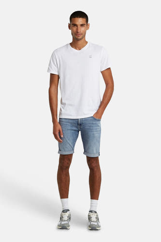 Short en jean bleu clair de G-Star RAW avec ourlets retroussés, porté par un homme avec un t-shirt blanc et des baskets.