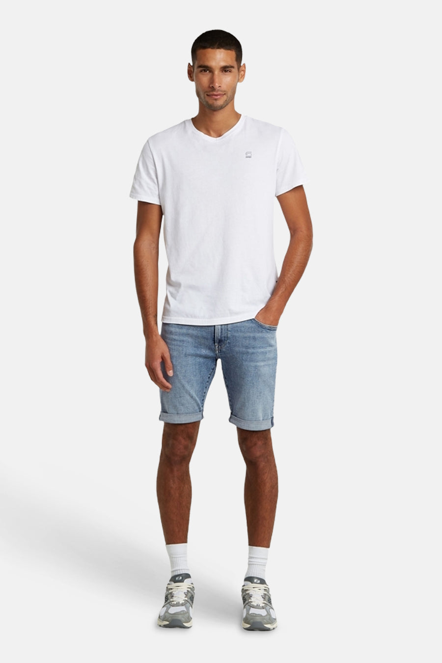 Short en jean bleu clair de G-Star RAW avec ourlets retroussés, porté par un homme avec un t-shirt blanc et des baskets.